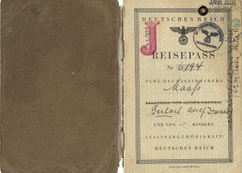 Photo d'un document brun et beige, rédigé en allemand, incluant une signature manuscrite. La page ouverte a un grand “J” rouge estampé sur le coin supérieur.