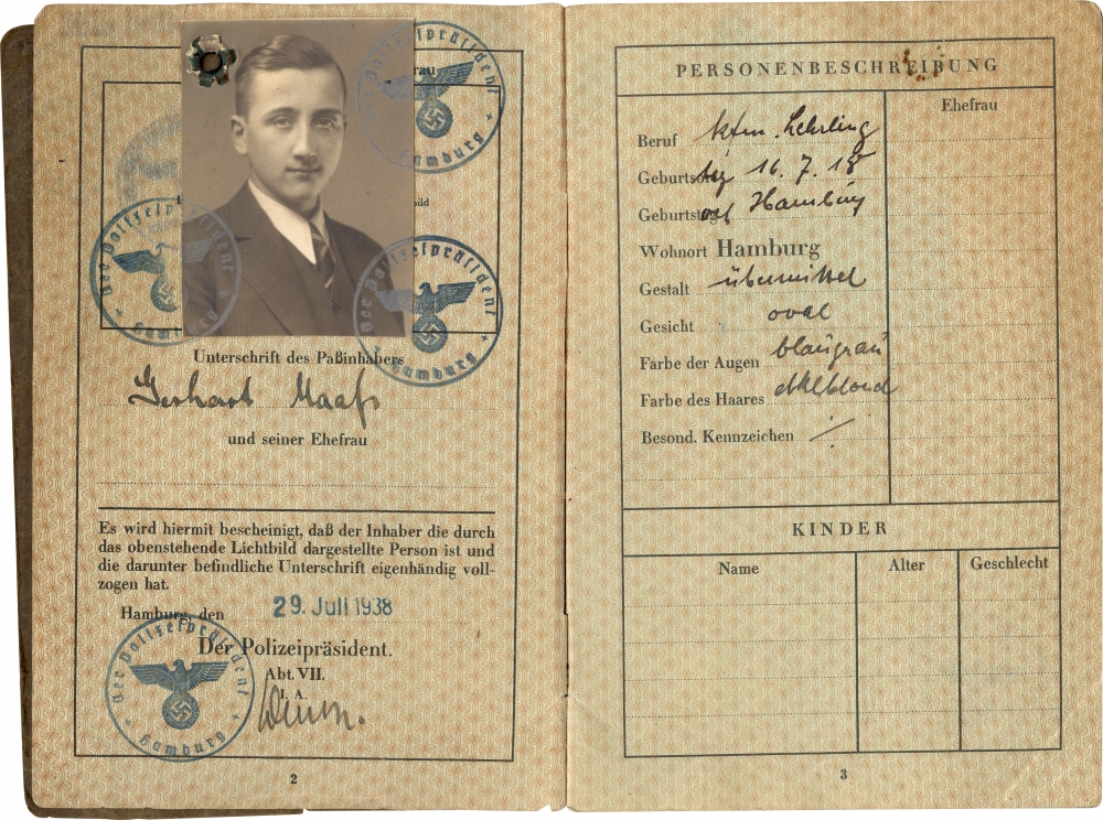 Deux pages d'un passeport avec des estampes bleues et de l'écriture noire. Il y a une photo d'identité en noir et blanc d'un jeune homme portant un costume et une cravate sur la page de gauche.