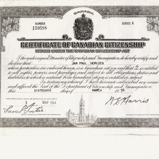 Photocopie en noir et blanc d'un document avec un bordure très décorée dans laquelle il y a des feuilles d'érable et une gravure du Parlement canadien dans le bas de la bordure. Le certificat a une écriture en italique et deux signatures.