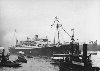 Black and white photograph of a passenger ship surrounded by smaller boats.