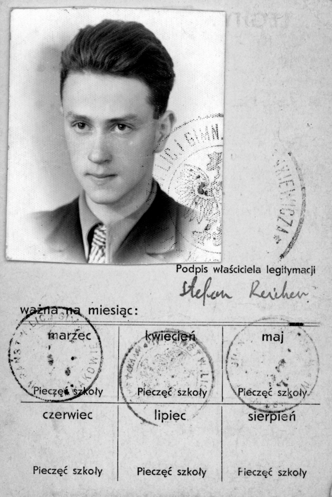 Black-and-white document with a photograph in top-left corner of a young man with combed-back hair, wearing a suit and tie. The document contains Polish writing, four stamps, and a signature.