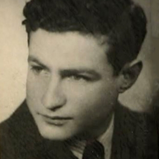 Photo en noir et blanc du profil d'un jeune homme, regardant vers la gauche de la caméra. il porte un complet et a des cheveux bruns foncés bouclés.