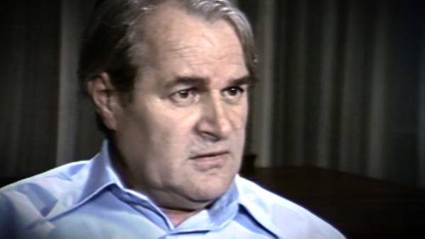 Capture d'écran du témoignage vidéo du survivant de l’Holocauste Aba Beer, assis devant un fond gris, et regardant à la droite de la caméra. Son visage et ses épaules sont visibles à la caméra.