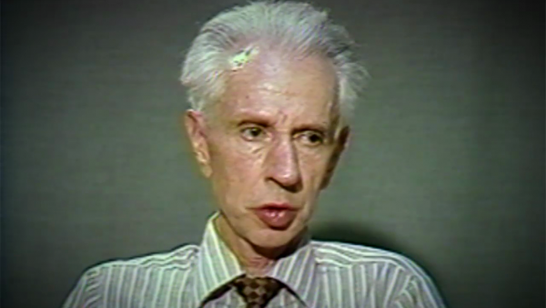 Capture d'écran du témoignage vidéo du survivant de l’Holocauste Stefan Carter, assis devant un fond noir, et regardant à la droite de la caméra. Son visage et ses épaules sont visibles à la caméra.